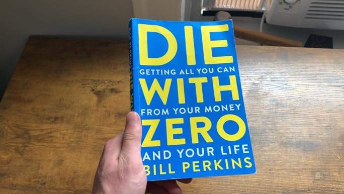 Picture of a hand holding the Die with zero book by Bill Perkins